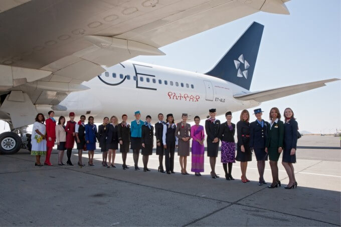 Staff representatives from Star Alliance member airlines, dressed in their official uniforms, pose beneath the wing of Ethiopian Airlines' Star Alliance liveried 767. The uniformed staff gathered in Addis Ababa for the official ceremony marking Ethiopian's joining of Star Alliance.